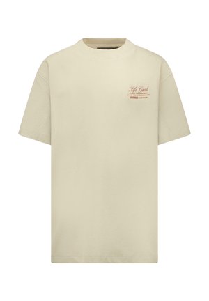 Beige T-shirt met korte mouwen en een ronde hals, met kleine bruine tekst "Life Goals Escape the Ordinary Chase the Extraordinary" op de linkerborst.