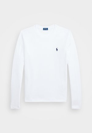 T-shirt blanc à manches longues avec col rond, petit logo joueur de polo brodé en bleu foncé sur la poitrine gauche et étiquette bleue à l'intérieur du col.