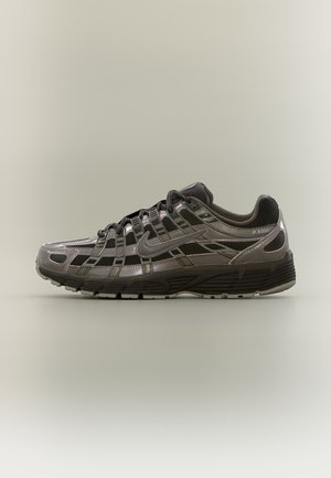 Zwarte en donkergrijze Nike P-6000 sneaker met mesh en synthetische overlays, zijkant swoosh-logo en vetersluiting op een lichte achtergrond.