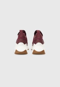Burgundy athletic shoes with a textured upper, white midsole, and brown rubber sole. Features pull tabs and a circular logo accent.