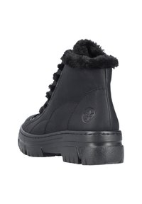 Bottes chelsea en cuir noir avec une finition texturée, doublure en fourrure au col, et une épaisse semelle en caoutchouc avec un motif de crampons proéminent.