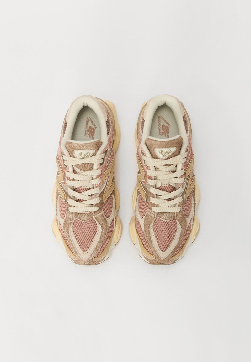 New Balance 9060 Sneaker mit einem Obermaterial aus Mesh und Wildleder in Beigetönen und Rosa, ausgestattet mit cremefarbenen Schnürsenkeln, einer Gummisohle und Logo-Akzenten.