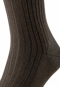 Calzino a coste di colore marrone scuro realizzato in materiale testurizzato, caratterizzato da strisce verticali distintive e una cucitura liscia sulla punta per un comfort aggiuntivo.