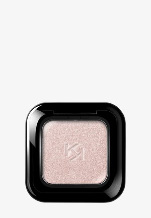 Square black compact containing shimmery light pink pressed powder eyeshadow with embossed initials in the center.