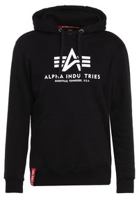 Zwarte hoodie van zachte stof met een voorzak met kangoeroe, een capuchon met trekkoord en een wit gedrukt logo met drie strepen. Rode accentlabel aan de zoom.