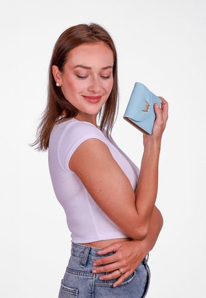 Light blue leather wallet with a gold lightning bolt accent, fold-over design, and smooth texture, held by a person against a plain background.