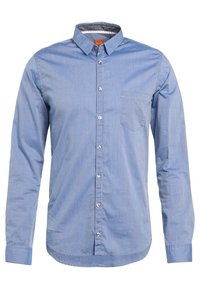 Světle modrá košile s dlouhými rukávy vyrobená z bavlny, má límec s knoflíky, jedno náprsní kapsičku a jemný pruhovaný vzor.
