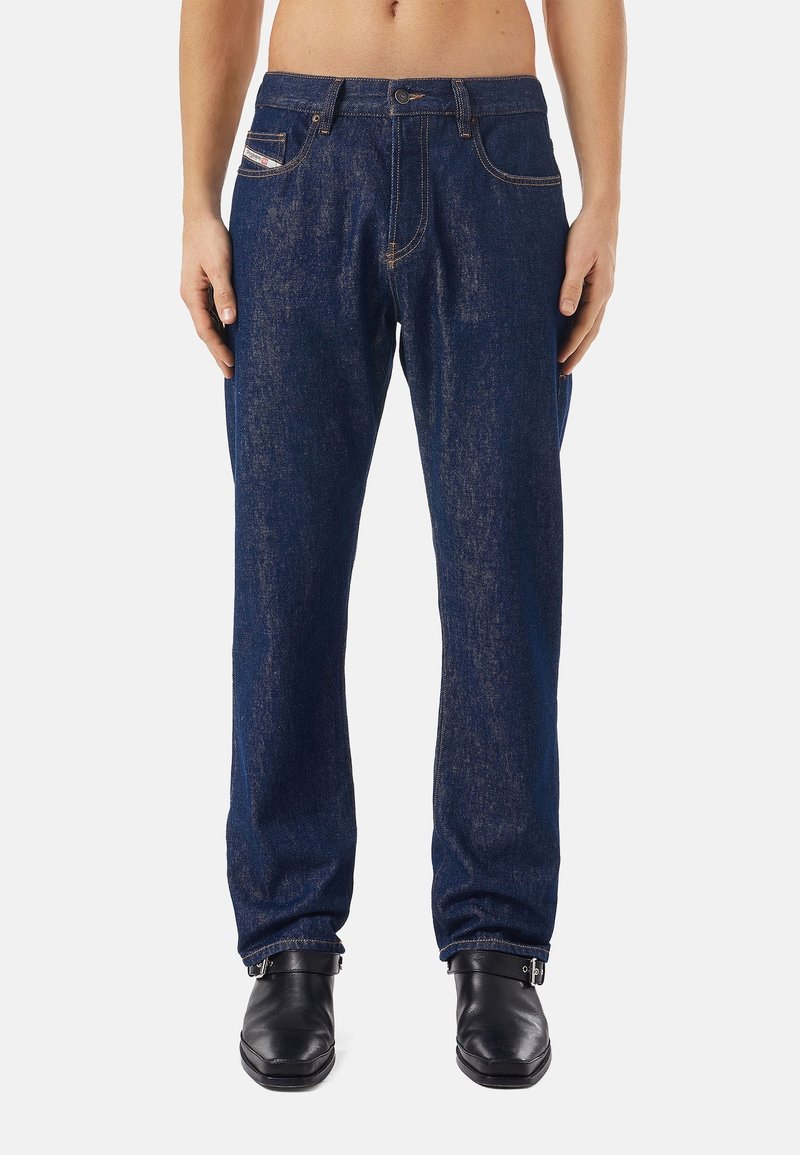 Mörkblå denimjeans med rak bendesign, synlig sömnad, femfickorsstil och knappstängning i midjan.