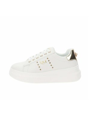 Basket en cuir blanc avec une semelle épaisse blanche, des accents en métal doré sur le talon et des clous décoratifs dorés sur le côté.