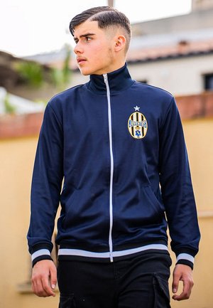 Marine blauw zip-up jack met hoge kraag, witte accenten en een Juventus-logo op de borst; gladde textuur, atletische stijl en zijzakken.