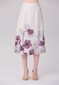 Jupe midi à motifs floraux en tissu léger et doux. Présente de grandes fleurs violettes et grises sur un fond pâle. Texture lisse.