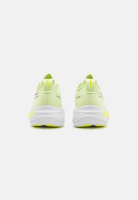 Scarpe da ginnastica verde chiaro con suole bianche e dettagli gialli, dotate di tomaia in rete e tallone imbottito per il comfort.