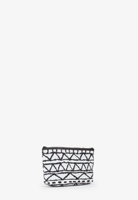 Pochette in tela bianca e nera con un motivo geometrico, forma rettangolare e chiusura a zip nella parte superiore. Superficie testurizzata.