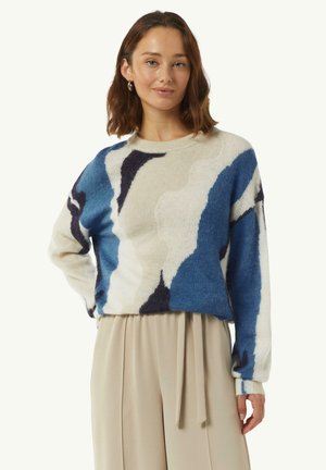 Pullover blu e crema a fantasia con scollatura rotonda, maniche lunghe e vestibilità rilassata. Tessuto morbido con elementi di design astratti.