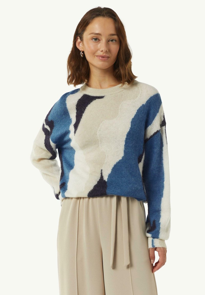 Blauer und cremefarbener Pullover mit Muster, rundem Halsausschnitt, langen Ärmeln und lockerer Passform. Weicher Stoff mit abstrakten Designelementen.
