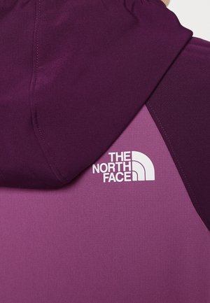 Purppuranvärinen hupputakki, jossa on kontrastina vaaleanpurppura paneeli ja valkoinen logodetalji sivulla. Sileä, kevyt kangas.