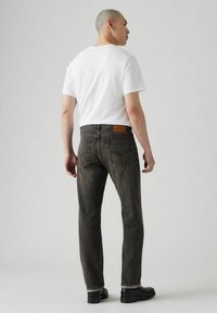 Donker gewassen denim jeans met een rechte pijp, afgewerkte zomen en subtiele stiksels. Gecombineerd met een eenvoudige witte t-shirt.