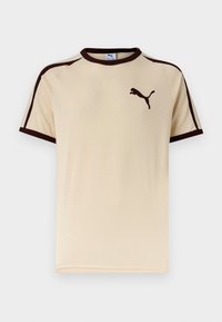 Μπεζ κοντομάνικη μπλούζα Puma με σκούρο καφέ περιθώριο στα μανίκια και το γιακά και το λογότυπο της Puma στο αριστερό μέρος του στήθους.