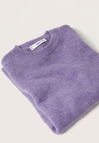 Pull en tricot lavande plié soigneusement, avec un col rond et un tissu doux et texturé. Étiquette visible au col.