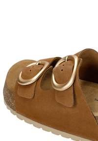 Sandale en daim marron avec deux larges brides et de grandes boucles dorées sur une semelle en liège avec une semelle extérieure beige clair.