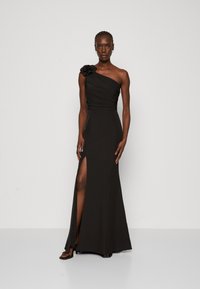 Rochie neagră, cu un umăr, accent floral, de lungime până la podea, cu fante pe lateral și textură netedă, oferind o siluetă elegantă.