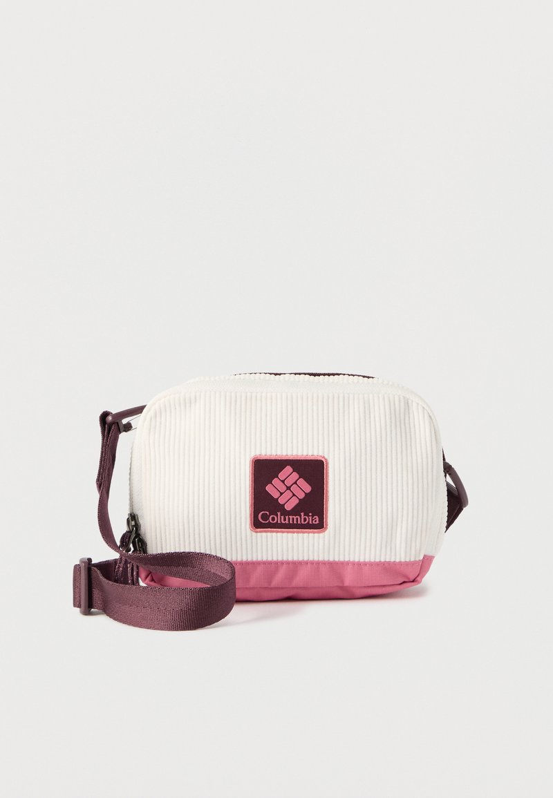 Compact cream- en roze Columbia crossbodytas met gestructureerde stof, rechthoekige vorm, voorzijde met logopatch en verstelbare donkerpaarse band.