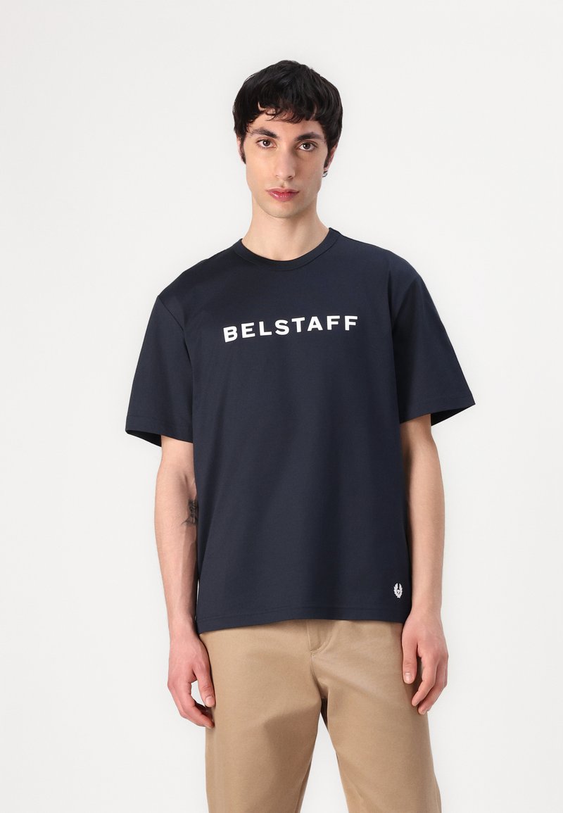 Sötétkék pamut póló, rövid ujjal és kerek nyakkivágással, fehér "BELSTAFF" logóval a mellkasán.