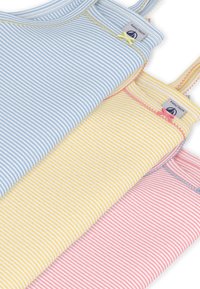 Τρία αμάνικα μπλουζάκια σε έκθεση: ένα ανοιχτό μπλε, ένα κίτρινο με λευκές ρίγες και ένα ροζ. Διαθέτουν λεπτές τιράντες και πολύχρωμες ραφές ως διακοσμητικά στοιχεία.
