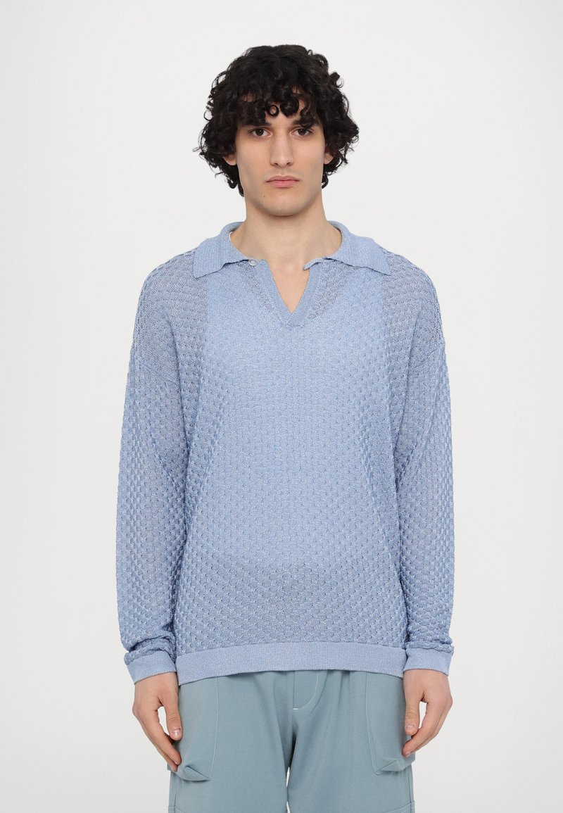 Pullover lavorato a maglia blu chiaro con un motivo testurizzato, colletto e maniche lunghe. Polsini e orlo a coste.
