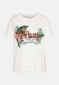 Vit T-shirt med en tiger-design bland gröna blad och rosa blommor, med glittrig text som säger "PARADISE Wish you were here!"