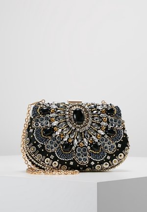 Pochette noire décorée de perles et pierres précieuses dorées, argentées et noires en motifs floraux, avec une bandoulière chaîne dorée.