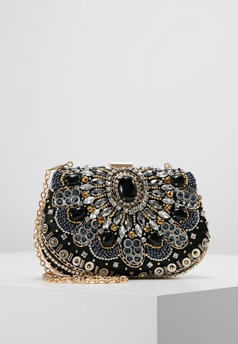 Pochette noire décorée de perles et pierres précieuses dorées, argentées et noires en motifs floraux, avec une bandoulière chaîne dorée.