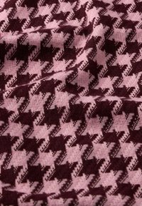 Tessuto lavorato a jacquard con motivo a pied de poule in un intenso bordeaux scuro e rosa chiaro, caratterizzato da una consistenza morbida e una leggera profondità.