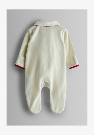 Un overol color crema con un cuello blanco y costuras rojas. Mangas largas con puños rojos, textura suave y diseño con pies para mayor calidez.