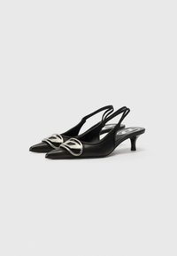 Pantofi slingback din piele neagră, cu bot ascuțit, toc mic de tip kitten și un detaliu proeminent din metal argintiu în față.