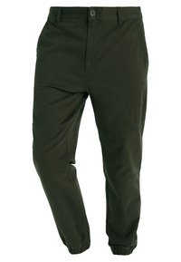 Ciemnozielone spodnie bawełniane o dopasowanym kroju, z elastycznymi mankietami, praktycznymi kieszeniami i subtelnymi detalami szycia.