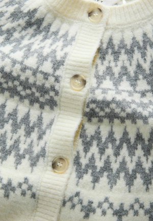 Uldcardigan med en cremefarvet base og et gråt geometrisk mønster. Ribbet krave og knapstolpe med store cremefarvede knapper. Blød tekstur.