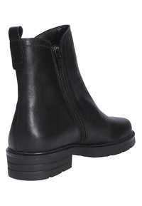 Bottine en cuir noir avec fermeture éclair sur le côté, bout arrondi et semelle en caoutchouc texturée. Comprend une languette à l'arrière pour un enfilage facile.
