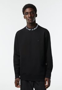 Zwarte sweatshirt van een katoenmix, met een ronde hals en een witte merkboord, lange mouwen en een klein logo op de borst.