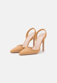 Sapatos de salto alto nu com biqueira afunilada, material de couro suave e design de parte traseira aberta. Apresenta um salto fino estilo stiletto.