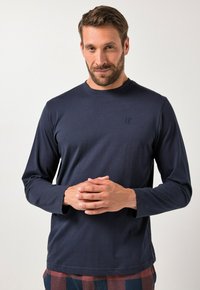 Camisa de manga larga de color marino hecha de una tela suave, con un cuello redondo y un logo sutil en el pecho. Textura suave y diseño ajustado.