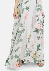 Kwiatowy kimono wykonane z lekkiego, przezroczystego materiału w kolorze białym, z różowymi i zielonymi nadrukami roślinnymi, z otwartym przodem i zwiewną sylwetką.