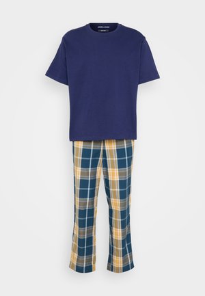 Mornarsko modra bombažna majica v kombinaciji s karirastimi hlačami v odtenkih teal, rumene in sive. Ohlapen kroj, kratki rokavi in ravne hlače.