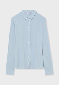 Blusa button-up a maniche lunghe di colore azzurro chiaro con colletto a punta, sette bottoni davanti e polsini stretti sulle maniche.