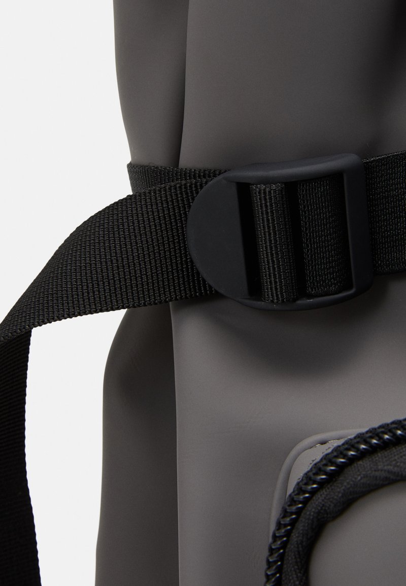 Borsa impermeabile grigia con finitura texturizzata, dotata di una tracolla nera e una chiusura a fibbia per una chiusura sicura.