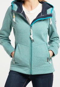 Chaqueta con capucha en color teal, fabricada en un tejido texturizado con forro en contraste navy, que cuenta con cordones ajustables y dos bolsillos laterales con cremalleras.