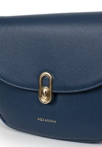 Borsa a tracolla in pelle blu navy con finitura testurizzata, dotata di una chiusura in metallo dorato e con il marchio "HEXAGONA" impresso sul davanti.