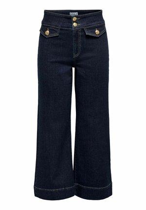 Jean large à jambes larges de couleur bleu foncé avec taille haute, deux boutons dorés et deux petites poches à rabat avec boutons dorés à l'avant.