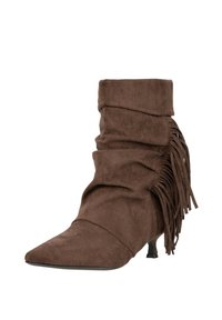 Brązowy zamszowy botek za kostkę o luźnym fasonie, z ostro zakończonym noskiem, niskim obcasem typu kociak oraz ozdobną frędzlową dekoracją po boku.