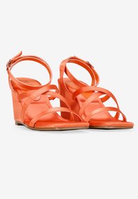 Sandalias de cuña de satén naranja con múltiples tiras cruzadas y una correa en el tobillo, con una textura suave y suela plana para mayor estabilidad.